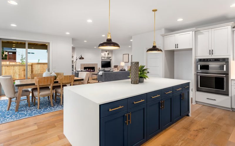 Custom waterfall island top with blue lower island cabinets in Oakland County Michigan kitchen remodel