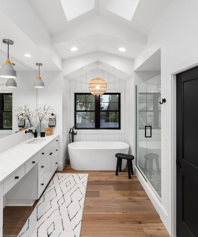 Lakeside + Addition premium bathroom with wood flooring by Reschka Design Build